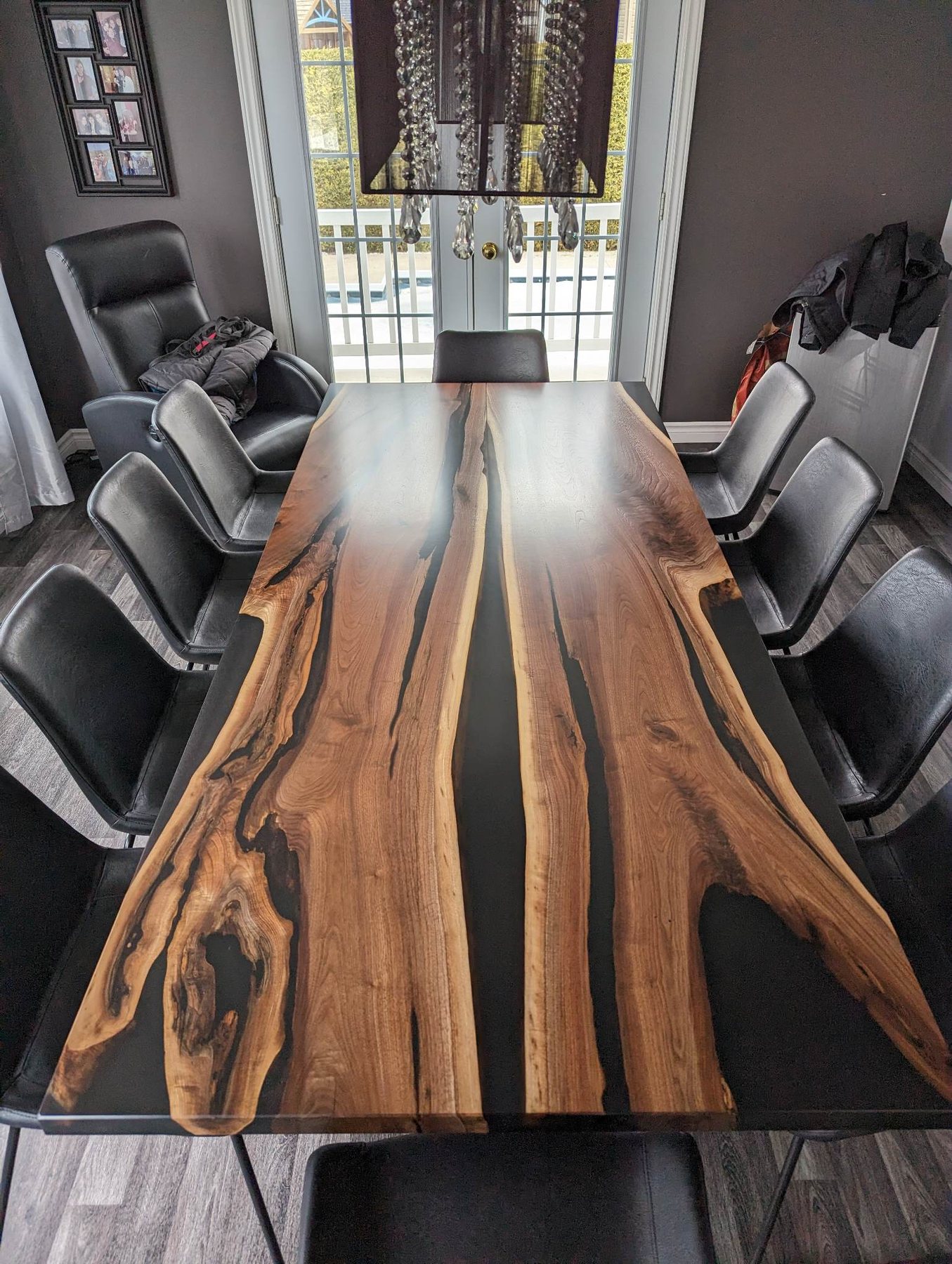 Grande table de conférence en noyer massif entourée de chaises noires
