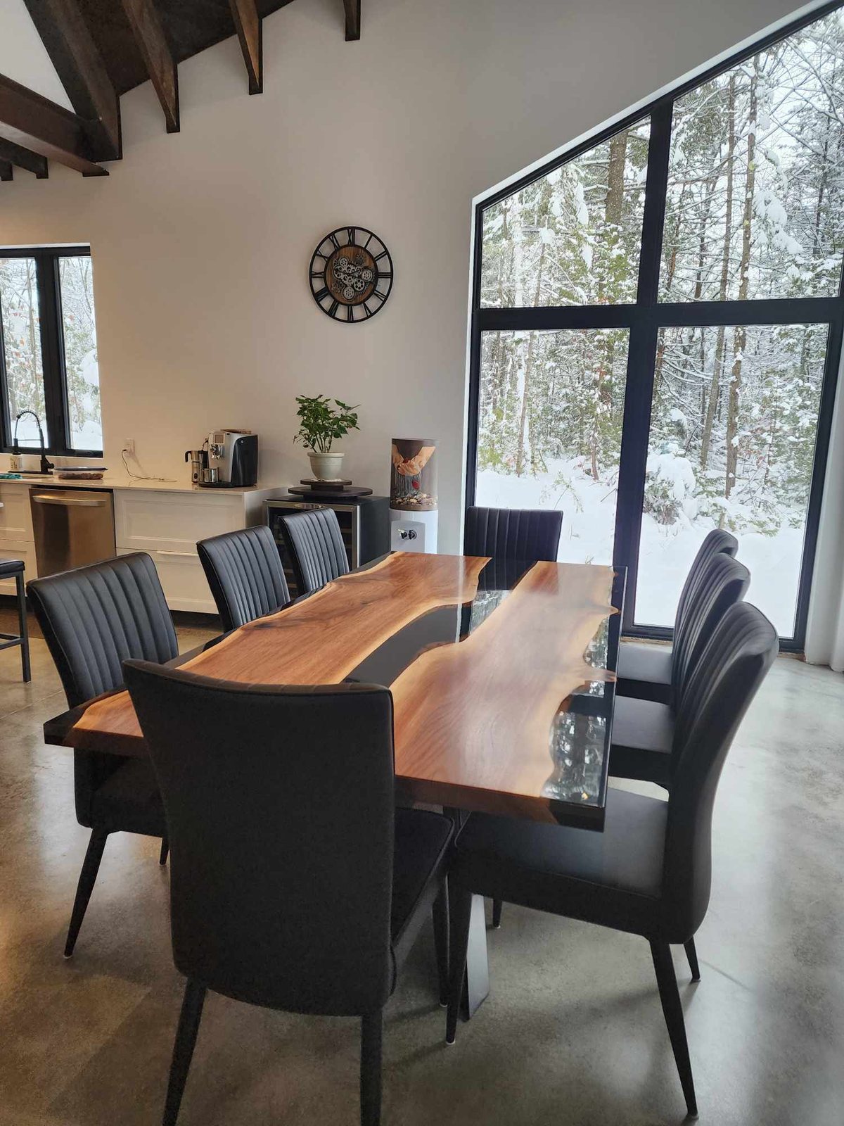 Table de repas en noyer massif dans une salle à manger avec grandes fenêtres